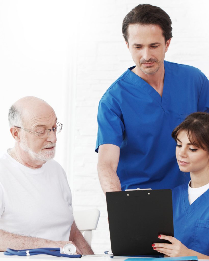 Happy senior patient and doctors in hospital